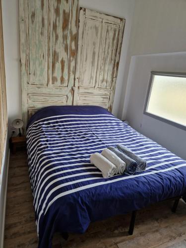 - un lit bleu et blanc avec 2 serviettes dans l'établissement La Baraquette de Thau, à Mèze