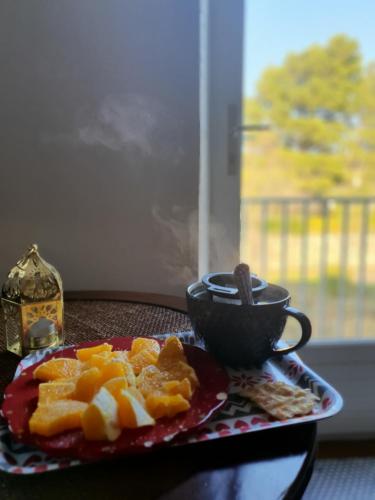 a plate of fruit and a cup on a table at La Barbacane de Cascastel-des-Corbières in Cascastel-des-Corbières