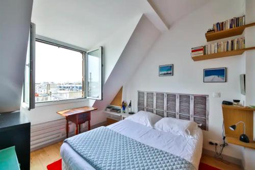 une chambre avec un lit, un bureau et une fenêtre dans l'établissement Les Toits de Paris Rue Cler Vue Tour Eiffel, à Paris