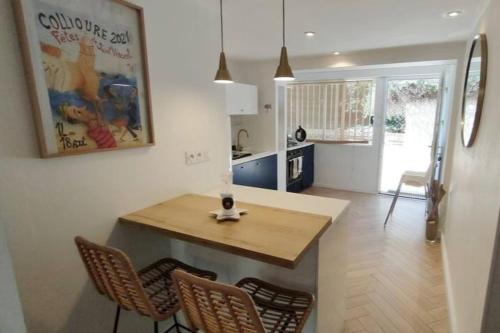 une cuisine avec une table et des chaises dans une pièce dans l'établissement Charme Collioure Wi-Fi Parking, à Collioure