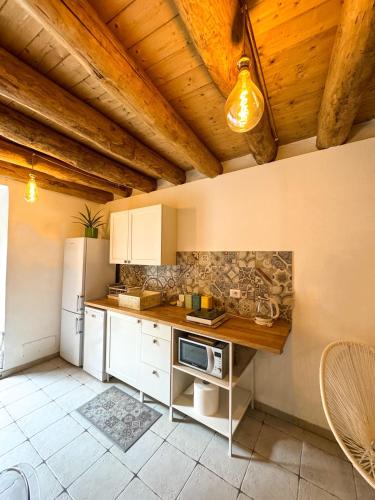 a kitchen with white cabinets and a wooden ceiling at Kalma - Universita Bastione Saint Remy in Cagliari