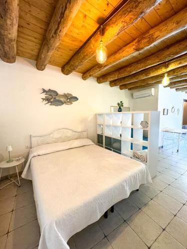 a bedroom with a white bed and a wooden ceiling at Kalma - Universita Bastione Saint Remy in Cagliari