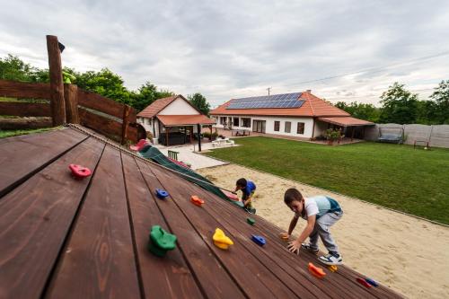 two children playing with toys on a wooden deck at Végállomás Vendégház in Göncruszka