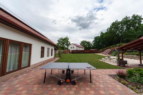 a ping pong table sitting on a brick patio at Végállomás Vendégház in Göncruszka
