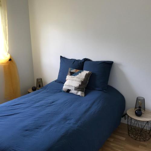 - un lit avec des draps bleus et un oreiller dans l'établissement VANNES Le PORT RCL, à Vannes