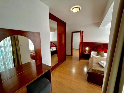 a room with a bedroom with a bed and a mirror at Prenoćište Euro-Jet Ćoralići in Ćoralići