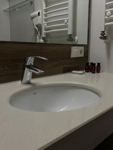 a bathroom sink with a faucet and a mirror at Bakuriani Orbi Palace Luxe Suite with Terrace and Breathtaking Views 462 in Bakuriani