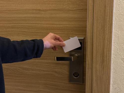 a person unlocking a door with a piece of paper at Bakuriani Orbi Palace Luxe Suite with Terrace and Breathtaking Views 462 in Bakuriani
