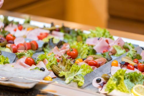 a tray filled with different types of salad on a table at Best Western Plus Hotel Füssen in Füssen