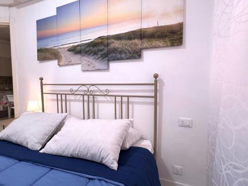 a bedroom with a bed with four paintings on the wall at La Casa Di Giorgio in Sanremo