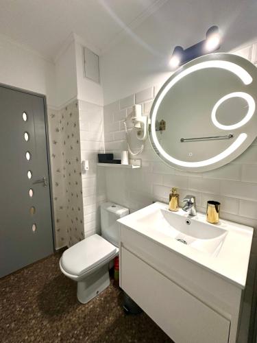 a bathroom with a sink and a toilet and a mirror at GOLD Apartment - Tomis Nord in Constanţa