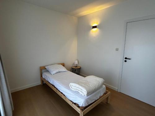 a small bedroom with a bed and a door at Appartement ' Little Lounge London' in Geel