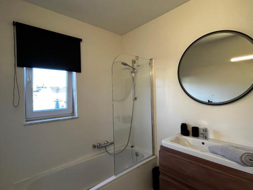 a bathroom with a shower and a sink and a mirror at Appartement ' Little Lounge London' in Geel