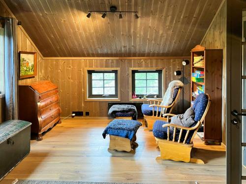 a living room with wooden walls and wooden floors at Modern Family Cabin At Vegglifjell in Veggli