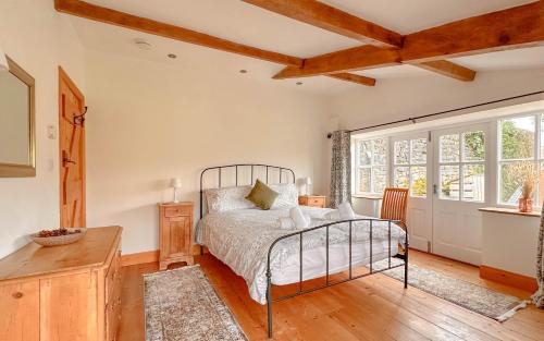 a bedroom with a bed and a wooden floor at 1 Swollowholm Cottage in Richmond