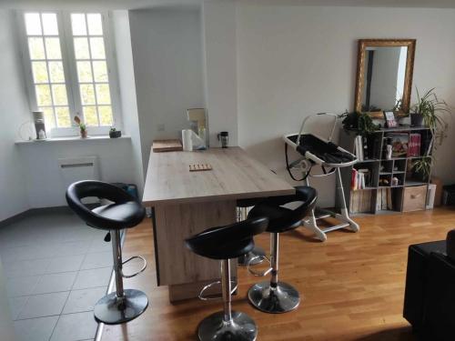 une pièce avec une table en bois et deux tabourets de bar dans l'établissement appartement centre ville, à Limoges