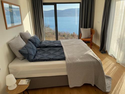a bedroom with a couch with a large window at Villa Ena in a peaceful location with a sea view in Zagorje