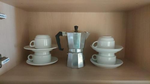 a shelf with two white cups and a blender at Aparthotel Siente Boí & SPA in Pla de l'Ermita