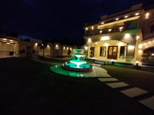 a building with a fountain in front of it at night at Emerald Villa Swat by Khan Familia Travels in Swat