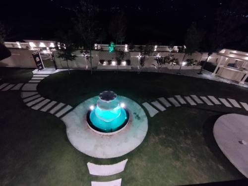 a fountain in the middle of a yard at night at Emerald Villa Swat by Khan Familia Travels in Swat