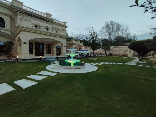 a house with a green fountain in the yard at Emerald Villa Swat by Khan Familia Travels in Swat