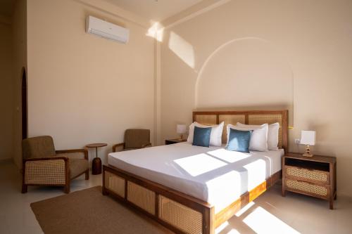 a bedroom with a large bed and a chair at Triton Dondra in Dondra West