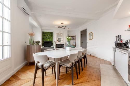 une cuisine et une salle à manger avec une table et des chaises blanches dans l'établissement Keyz - Luxury 3 Bedrooms near Champs Elysees, à Paris