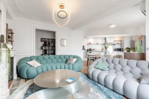 un salon avec deux canapés bleus et une table dans l'établissement Keyz - Luxury 3 Bedrooms near Champs Elysees, à Paris