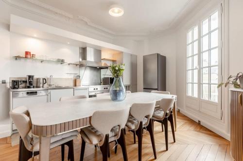 - une cuisine avec une table, des chaises et un vase fleuri dans l'établissement Keyz - Luxury 3 Bedrooms near Champs Elysees, à Paris