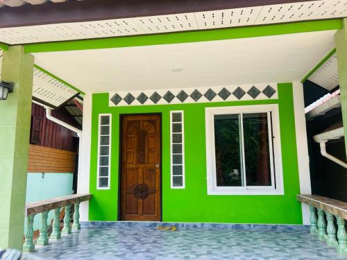a green house with a door and a window at Lamsai AC Sea House Green in Ko Yao Noi