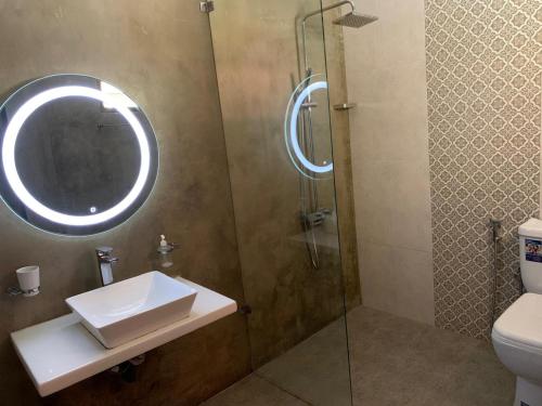 a bathroom with a sink and a shower with a mirror at Royal Crown Residency Hotel in Talawatugoda