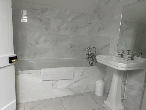 a white bathroom with a sink and a tub and a toilet at RusticRetreat-4Guests-Fireplace-Parking-Garden in Hinton Saint George