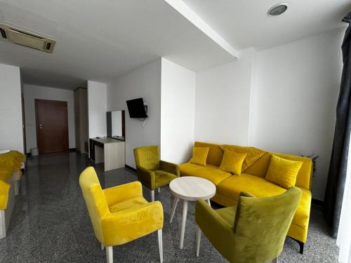 a living room with a yellow couch and yellow chairs at Prenoćište Euro-Jet Ćoralići in Ćoralići