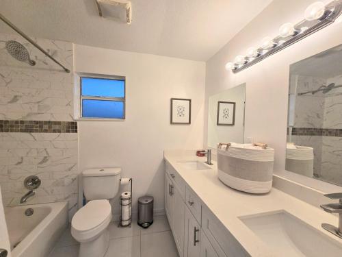 a white bathroom with a toilet and a sink at Green Keys Ranch in Homestead