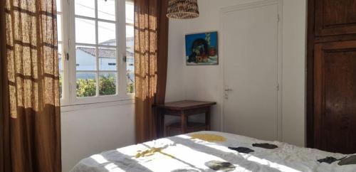 une chambre avec un lit et une fenêtre dans l'établissement Maison à 250m de la mer au calme sous les pins, à Bretignolles-sur-Mer