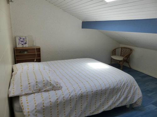 a bedroom with a white bed and a chair at HOSSEGOR Entre lac et océan Résidence LES DUNES, villa patio pour 4 à 5 personnes in Hossegor