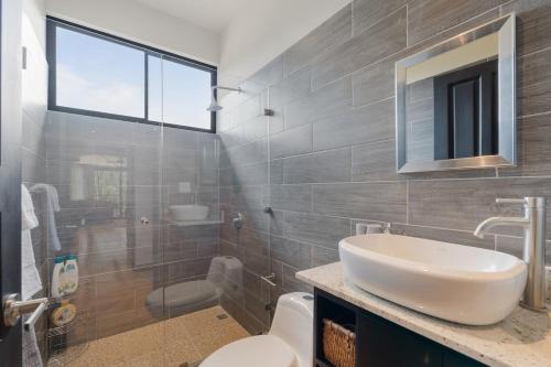 a bathroom with a sink and a toilet at Suite 4 Sloth - Pool&Beach 3 BR Condo in Brasilito