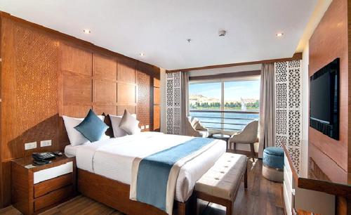 a hotel room with a bed and a television at Luxor Or Aswan Nile Cruise, Ultra Deluxe sailing 3, 4, Or 7 Nights in Luxor