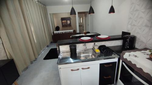 a kitchen with a sink and a stove in a room at KITNET DU VÔ - Cantinho Du Vô in Santa Teresa