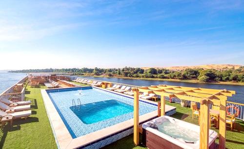 a large swimming pool on the side of a river at Luxor Or Aswan Nile Cruise, Ultra Deluxe sailing 3, 4, Or 7 Nights in Luxor