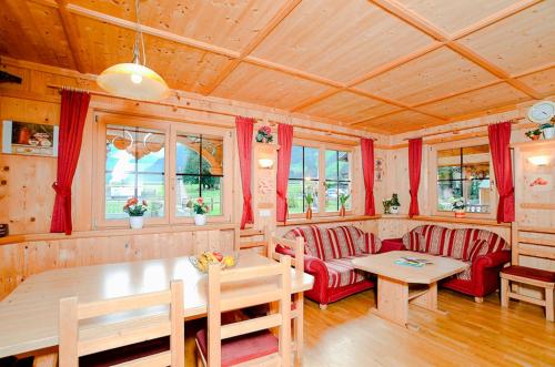 a living room with red furniture and a table at Ferienhaus Eberharter in Schwendau