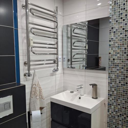 a white bathroom with a sink and a mirror at Apartament Agnes in Gniezno