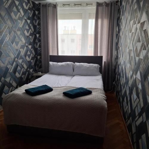 a bedroom with a bed with two pillows on it at Apartament Agnes in Gniezno
