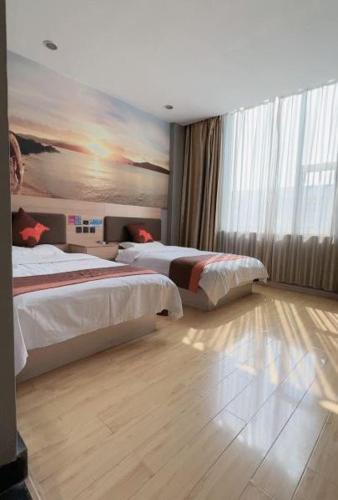 a bedroom with two beds and a painting on the wall at Junyi Hotel - Zaozhuang High Speed Railway Station in Taozhuang