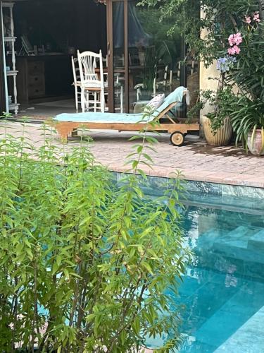 une cour avec une piscine, une chaise et une table dans l'établissement Syrah das Romantikzimmer, à Vacqueyras