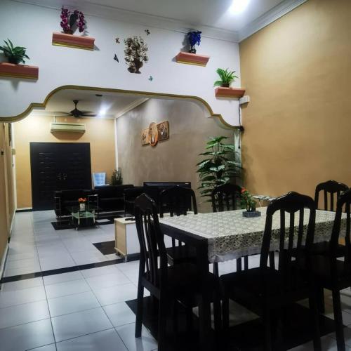 a dining room with a table and a couch at AR Happy Homestay in Segamat
