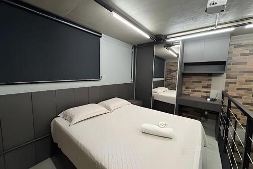 een kamer met een bed en een projectiescherm bij Loft Encantador em Araxá in Araxá