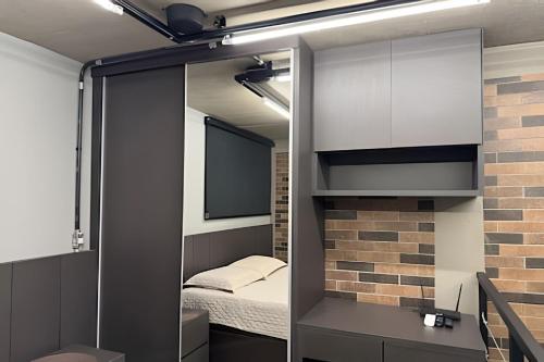 een kleine kamer met een bed en een spiegel bij Loft Encantador em Araxá in Araxá