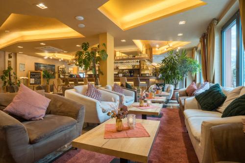 a lobby with couches and tables in a store at Best Western Plus Hotel Füssen in Füssen