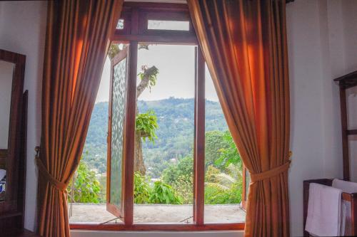 a window with a view of a mountain at Tedro home stay in Ampitiya